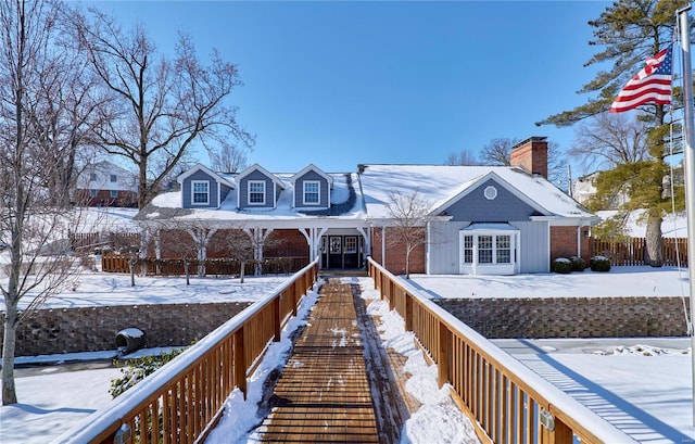 snow covered property with a chimney