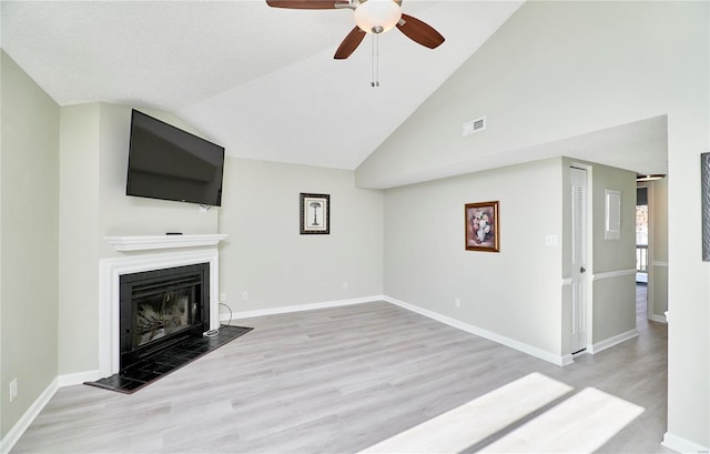 unfurnished living room with ceiling fan, a fireplace, baseboards, wood finished floors, and visible vents
