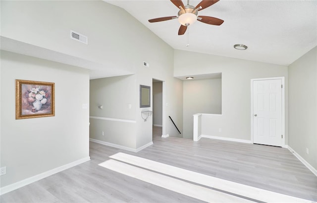 unfurnished room with visible vents, baseboards, high vaulted ceiling, light wood-type flooring, and a ceiling fan