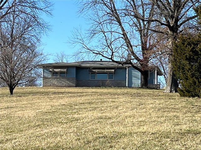 view of front of home featuring stone siding and a front yard