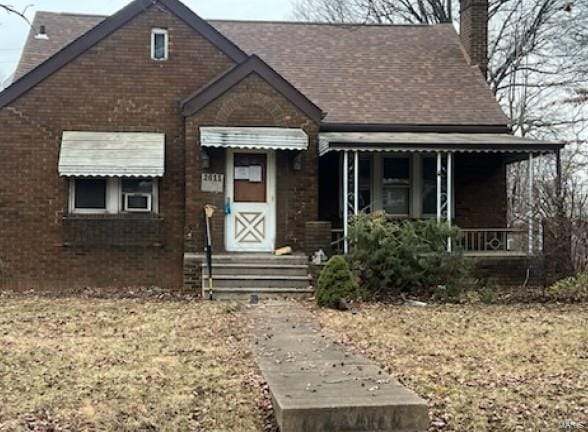 bungalow with brick siding and a chimney