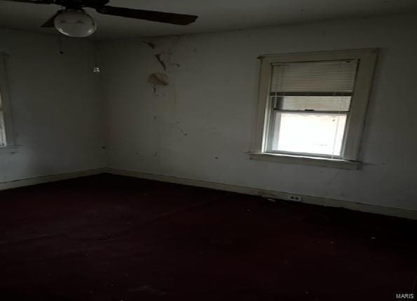unfurnished room with ceiling fan and baseboards