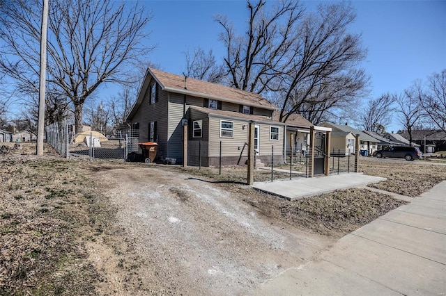 view of home's exterior featuring driveway, fence, and a gate