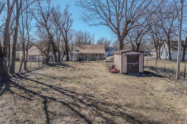 view of yard featuring an outbuilding, fence, and a storage shed