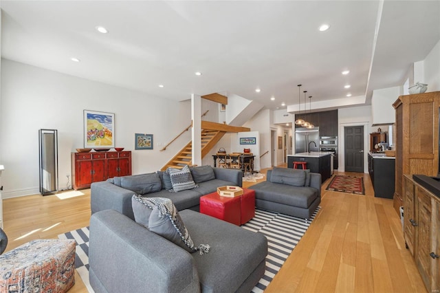 living area with stairway, recessed lighting, and light wood-style floors