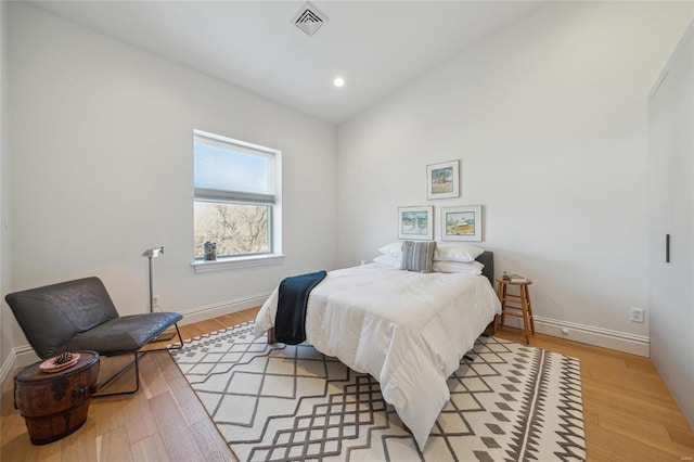 bedroom featuring light wood finished floors, visible vents, baseboards, lofted ceiling, and recessed lighting