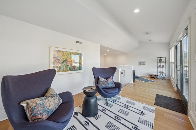 living area with light wood-style flooring, recessed lighting, visible vents, and baseboards