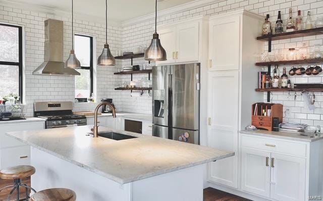 kitchen featuring open shelves, appliances with stainless steel finishes, white cabinets, a sink, and wall chimney exhaust hood