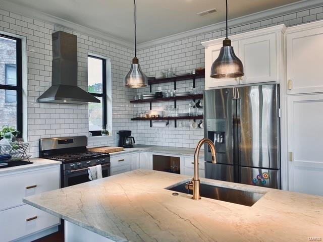 kitchen featuring a sink, appliances with stainless steel finishes, wall chimney range hood, and crown molding