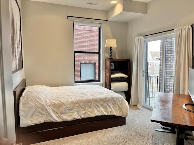 bedroom with carpet floors, multiple windows, a fireplace, and access to exterior