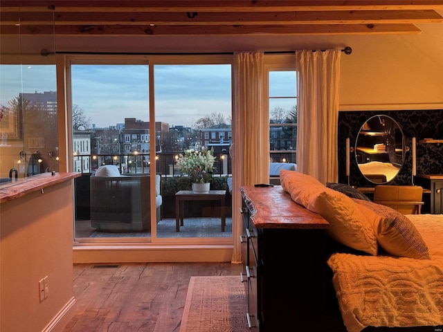 living room featuring a wealth of natural light, a view of city, visible vents, and wood finished floors