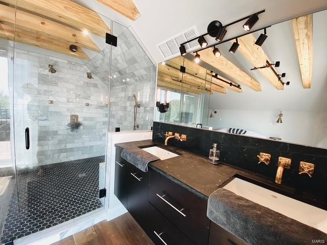 full bathroom featuring visible vents, a sink, a shower stall, and wood finished floors