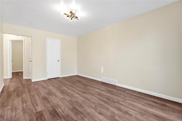 unfurnished bedroom with baseboards, visible vents, and wood finished floors