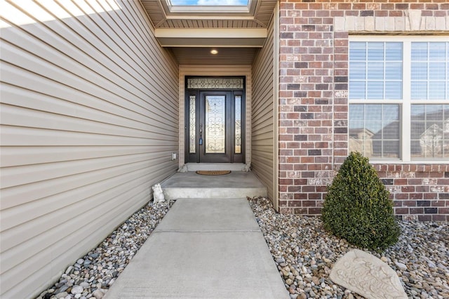 doorway to property featuring brick siding