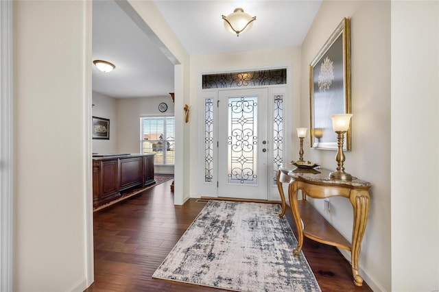 foyer featuring dark wood finished floors and baseboards