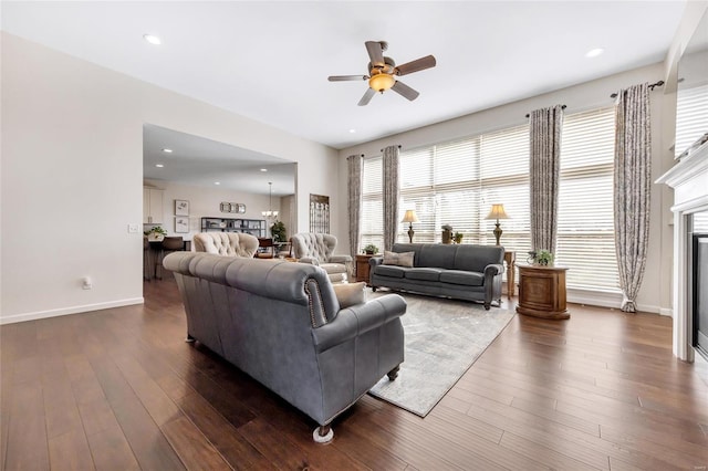 living room with recessed lighting, dark wood-type flooring, a glass covered fireplace, a ceiling fan, and baseboards