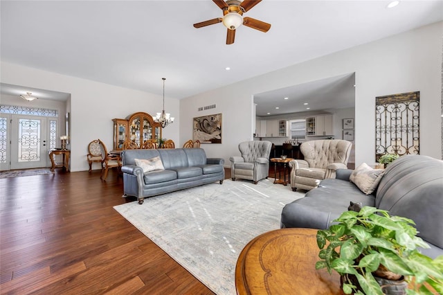 living area with ceiling fan with notable chandelier, recessed lighting, visible vents, and wood finished floors