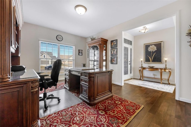 office area with dark wood-type flooring and baseboards