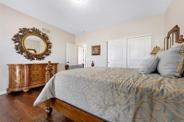 bedroom featuring dark wood-style flooring, a closet, and visible vents