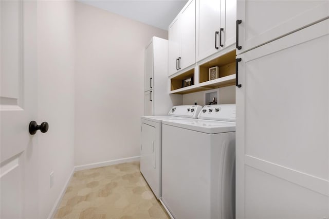 laundry area featuring separate washer and dryer, cabinet space, and baseboards