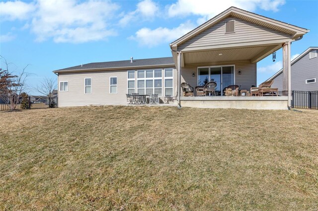 back of property featuring a yard, fence, and a patio