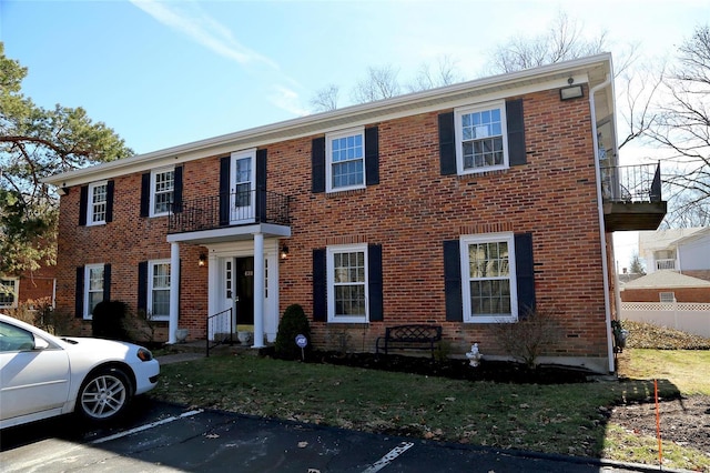 view of front facade featuring uncovered parking and brick siding