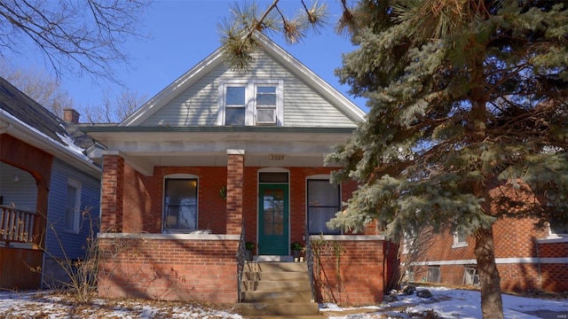 bungalow-style house with a porch and brick siding