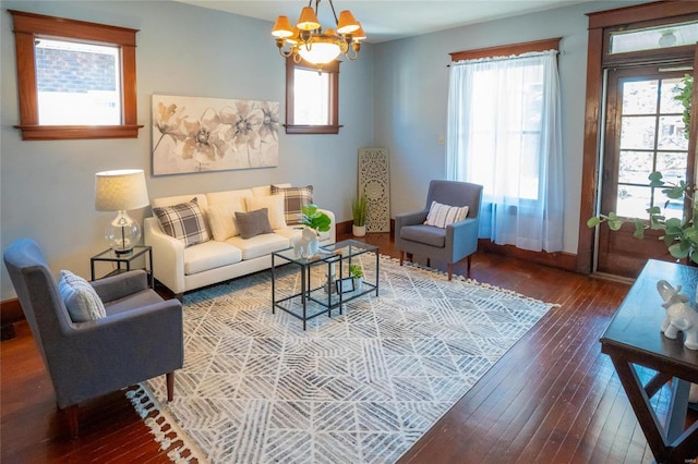 living room featuring a wealth of natural light, hardwood / wood-style flooring, and a notable chandelier