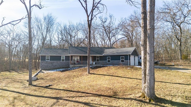 ranch-style house featuring a porch, stone siding, and an attached garage