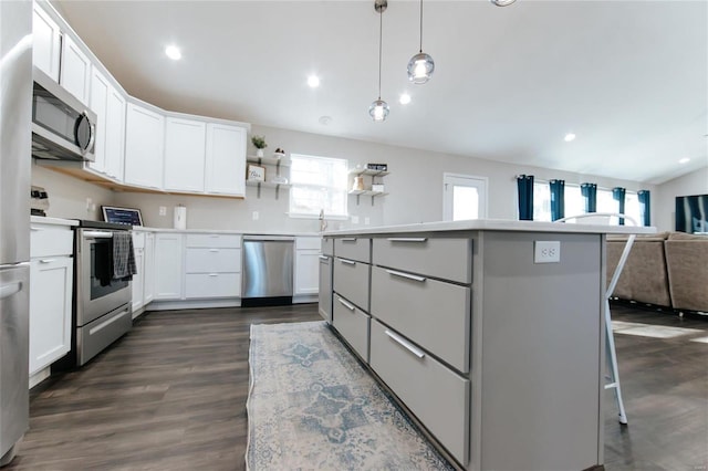 kitchen featuring a kitchen island, open floor plan, stainless steel appliances, white cabinetry, and open shelves