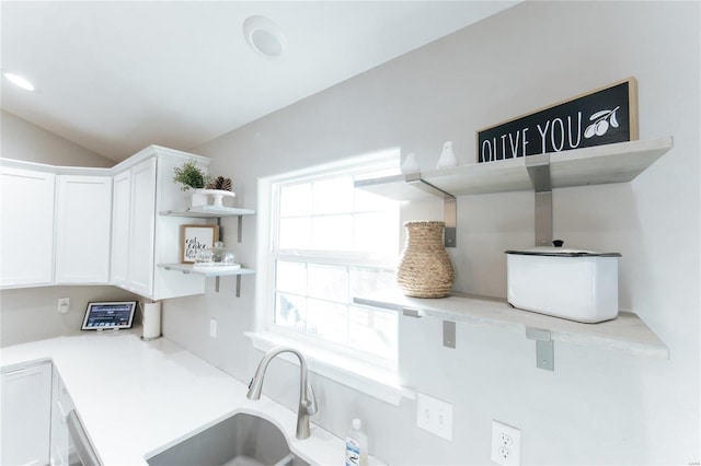 kitchen with white cabinets, lofted ceiling, light countertops, open shelves, and a sink