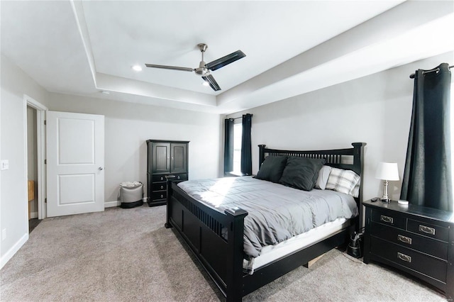 bedroom featuring recessed lighting, light carpet, a ceiling fan, baseboards, and a raised ceiling