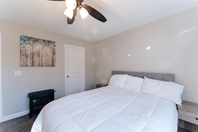 carpeted bedroom featuring a ceiling fan and baseboards