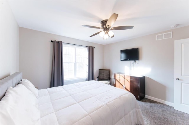 carpeted bedroom featuring a ceiling fan, visible vents, and baseboards