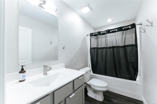 bathroom with toilet, shower / bathtub combination with curtain, wood finished floors, and vanity