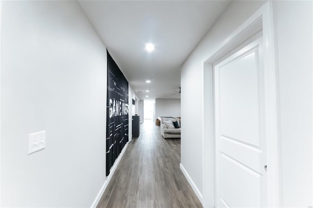 corridor with recessed lighting, wood finished floors, and baseboards