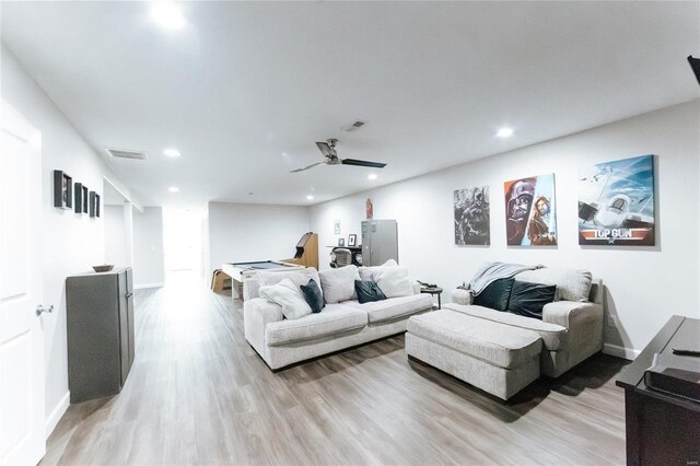 living area with recessed lighting, visible vents, light wood-style flooring, and baseboards