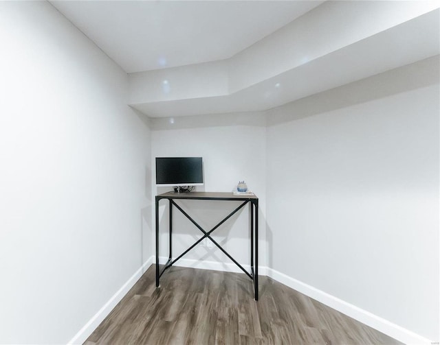 spare room featuring baseboards and wood finished floors