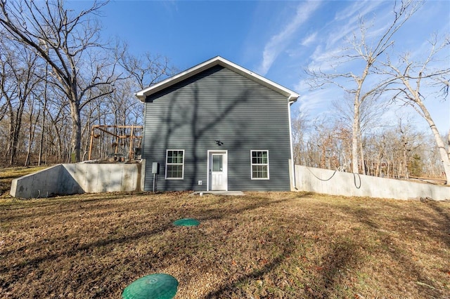 back of property featuring fence and a yard