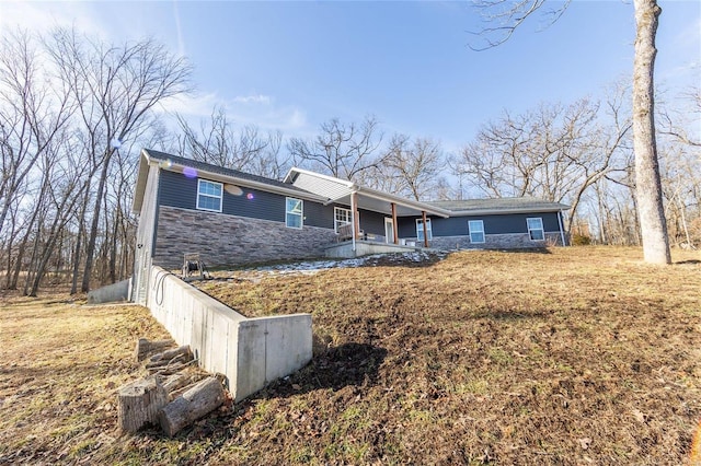 ranch-style home featuring stone siding and covered porch