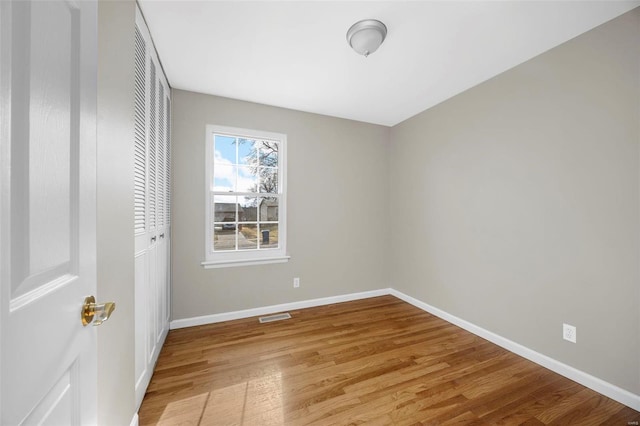 unfurnished bedroom with light wood-type flooring, baseboards, visible vents, and a closet