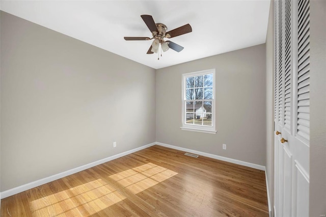 unfurnished bedroom featuring a closet, wood finished floors, visible vents, and baseboards