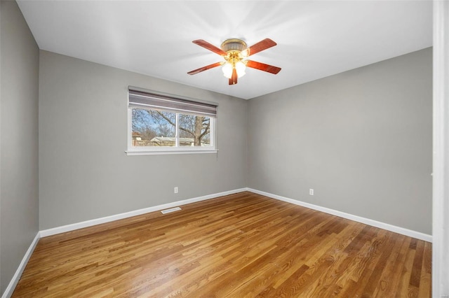 unfurnished room featuring light wood-style floors, baseboards, visible vents, and a ceiling fan