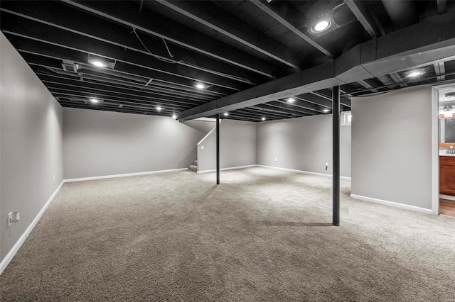 finished basement featuring carpet floors, stairway, and baseboards