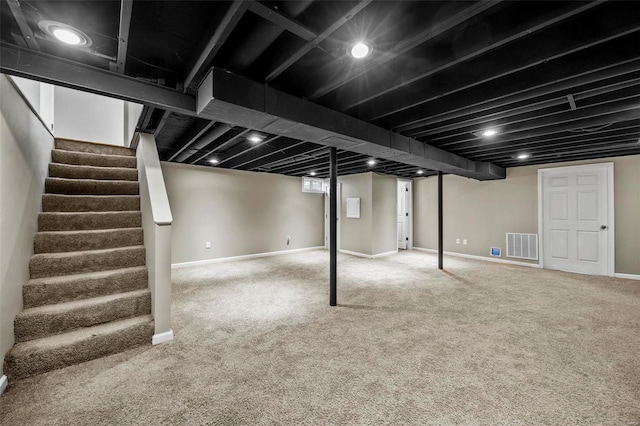 finished basement with stairs, carpet, visible vents, and baseboards