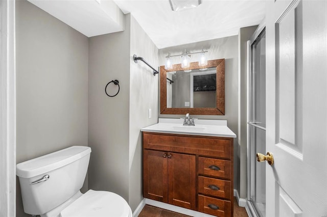 bathroom with a shower stall, toilet, and vanity