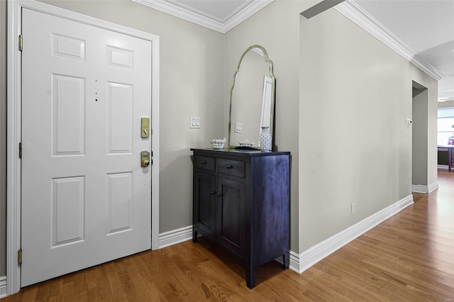 entrance foyer featuring ornamental molding, wood finished floors, and baseboards