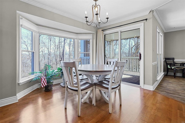 dining room with baseboards, a notable chandelier, ornamental molding, and dark wood-type flooring