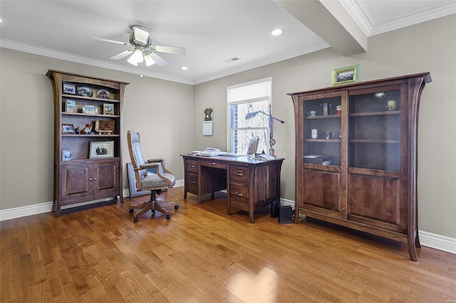 home office with a ceiling fan, baseboards, visible vents, light wood-type flooring, and crown molding