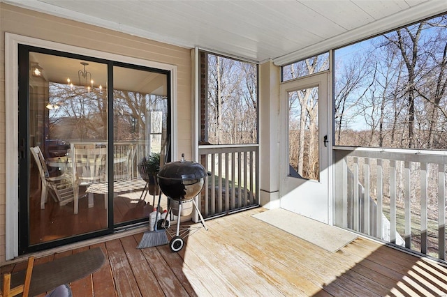 sunroom / solarium with a notable chandelier